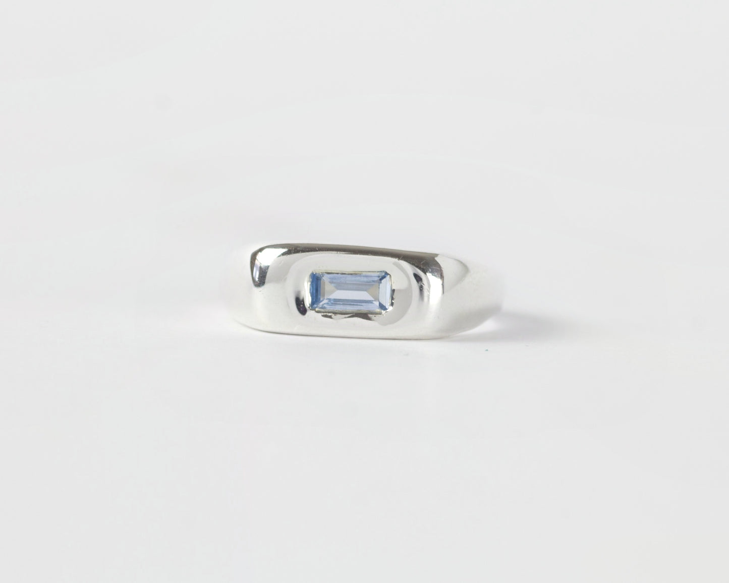 Front View of Light Blue Pillow ring in sterling silver by Meg Henry featuring a horizontal blue lab sapphire in a chunky sculptural signet-inspired design.