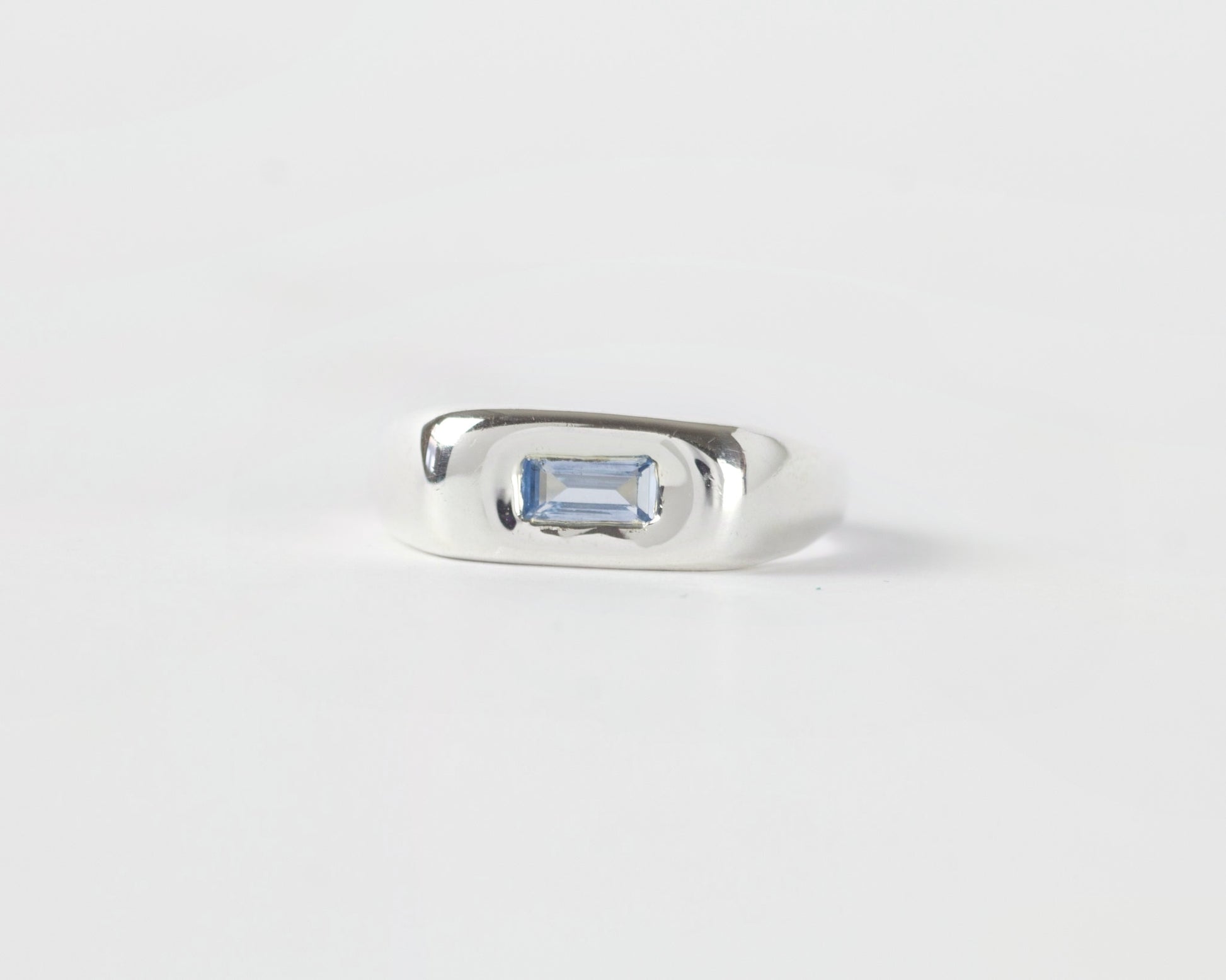 Front View of Light Blue Pillow ring in sterling silver by Meg Henry featuring a horizontal blue lab sapphire in a chunky sculptural signet-inspired design.