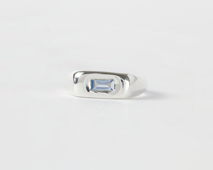 Front View of Light Blue Pillow ring in sterling silver by Meg Henry featuring a horizontal blue lab sapphire in a chunky sculptural signet-inspired design.