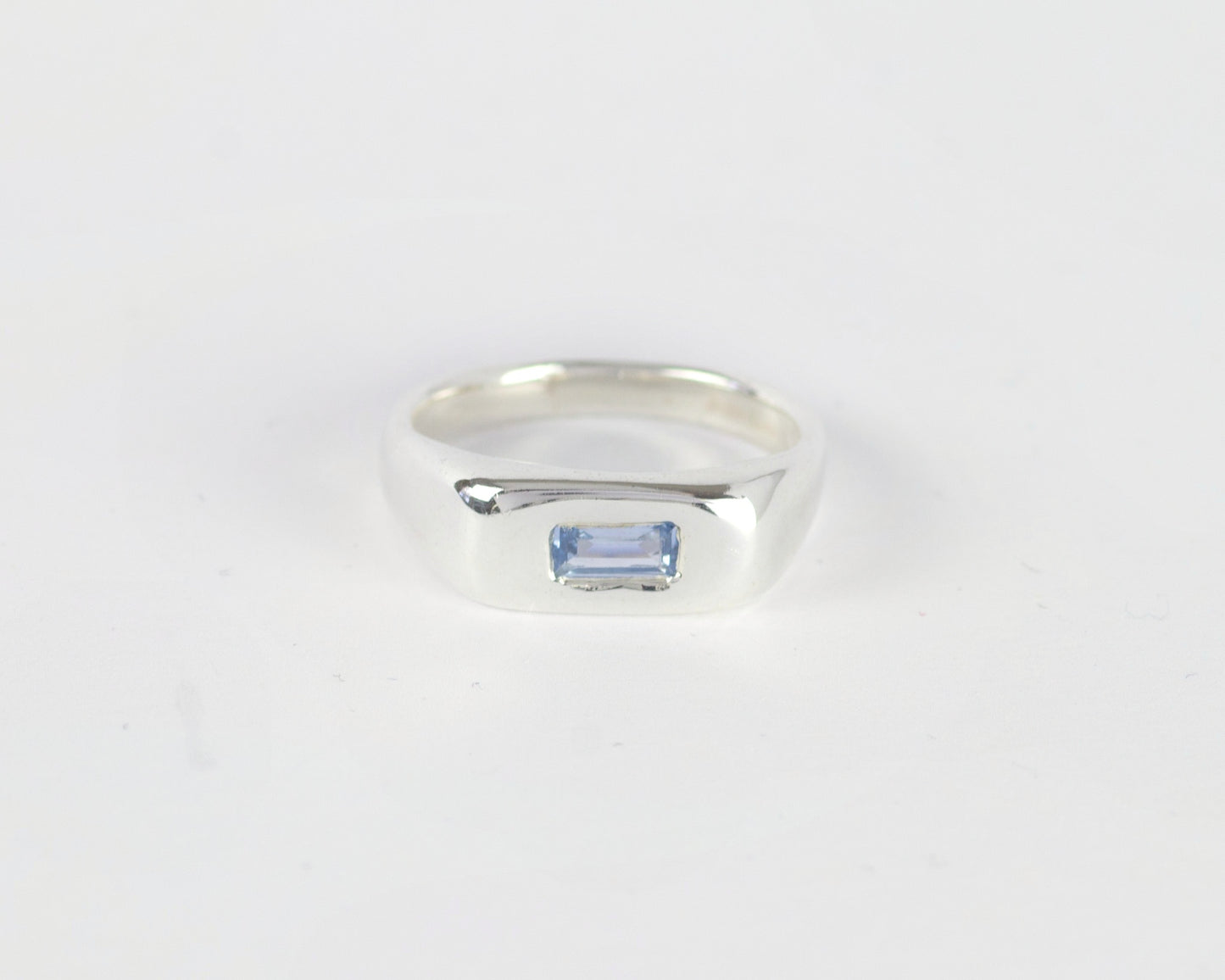 Top View of Light Blue Pillow ring in sterling silver by Meg Henry featuring a horizontal blue lab sapphire in a chunky sculptural signet-inspired design.