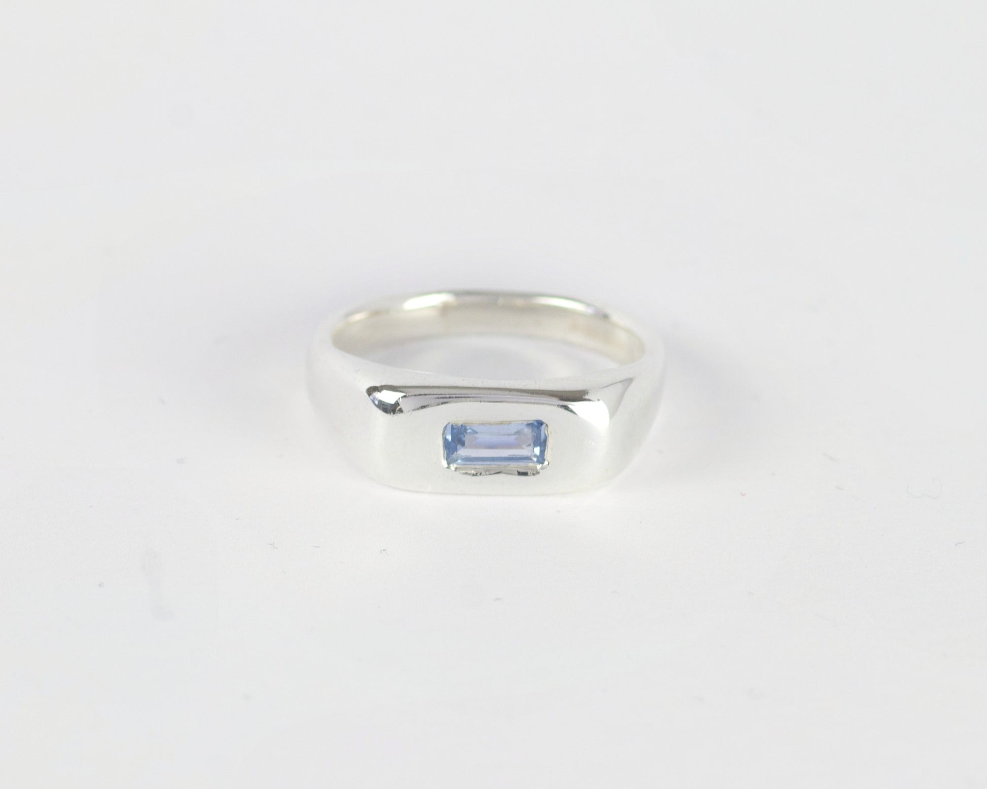 Top View of Light Blue Pillow ring in sterling silver by Meg Henry featuring a horizontal blue lab sapphire in a chunky sculptural signet-inspired design.