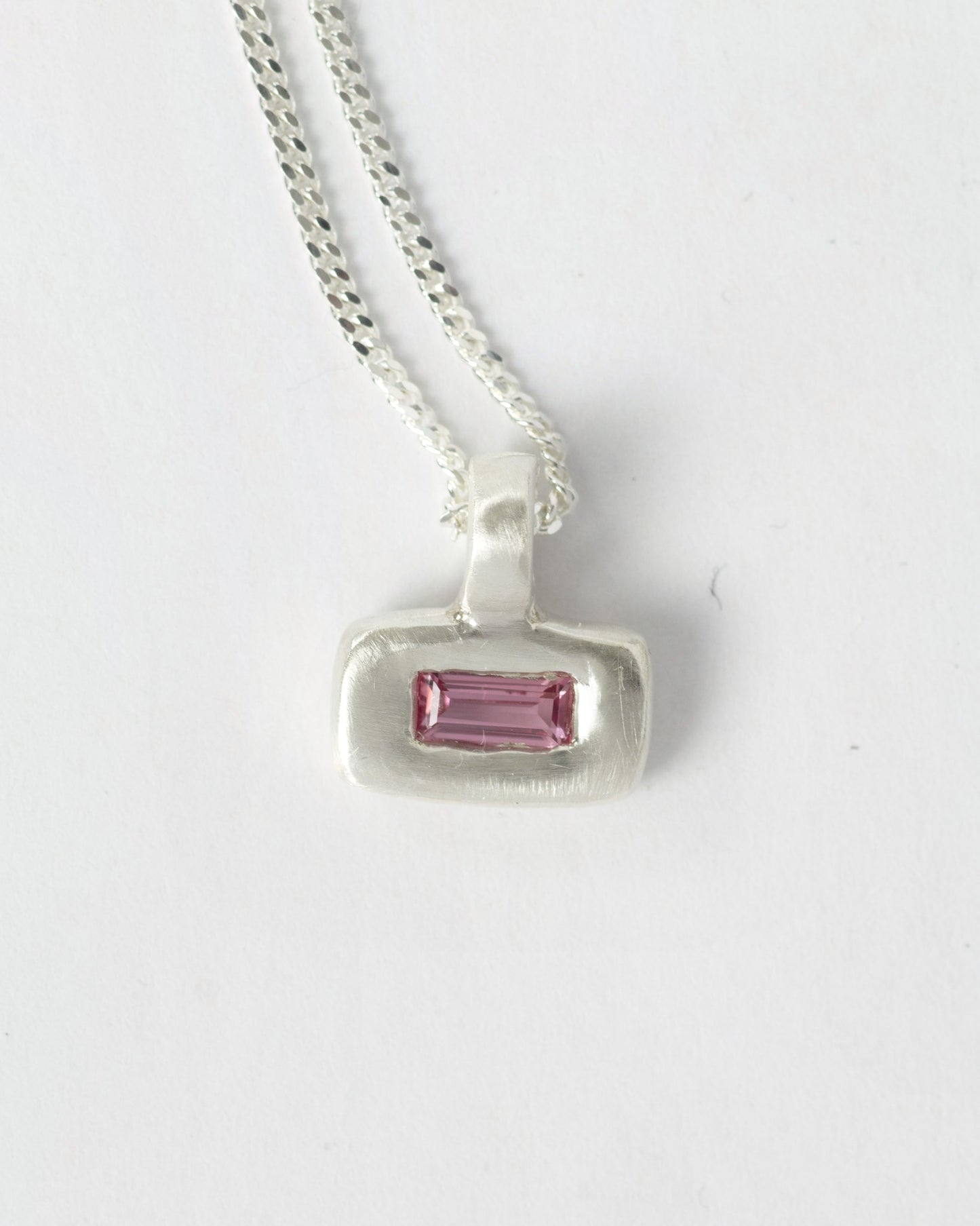 Pink Pillow pendant necklace in sterling silver by Meg Henry featuring a pink lab sapphire in a chunky satin-finished sculptural pendant on a curb chain