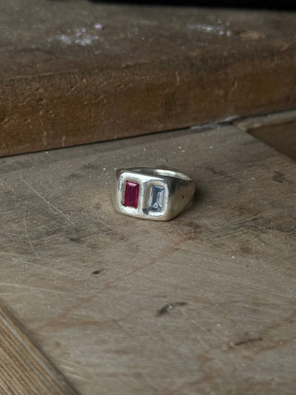 Blue and Ruby Pillow Pair ring in sterling silver by Meg Henry featuring a light blue spinel and lab ruby flush-set side by side.